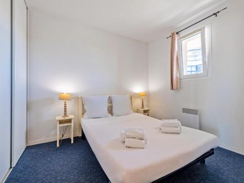 une chambre avec un grand lit blanc et une fenêtre dans l'établissement Sea-View Family Apartment, à Plougonvelin