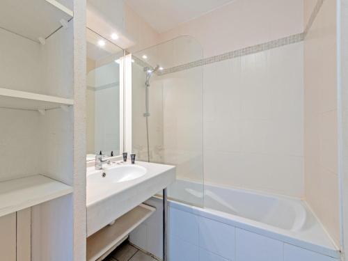 une salle de bain blanche avec un lavabo et une douche dans l'établissement Sea-View Family Apartment, à Plougonvelin