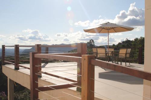 a balcony with an umbrella and a table and chairs at Casa Tramonto in Lavras Novas