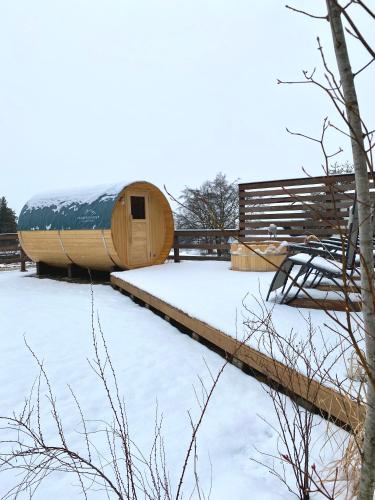 a wooden building in the snow with a tree at 一棟貸切Azumino36Stay 安曇野の静かな隠れ家 貸切サウナ BBQ 絶景テラス in Azumino