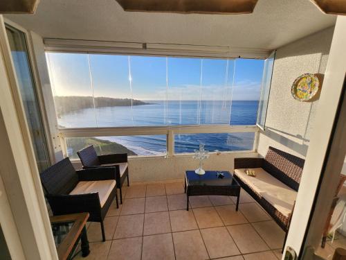 a room with a large window with a view of the ocean at Departamento Costa Quilén, Puchuncaví. (10 min de Maitencillo) in Valparaíso