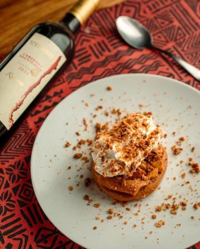 a white plate with a doughnut on a table at Sítio Flor das Águas in Lumiar