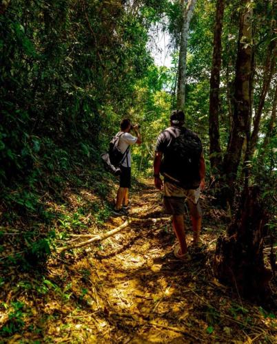 two people walking on a trail in the woods at Sítio Flor das Águas in Lumiar