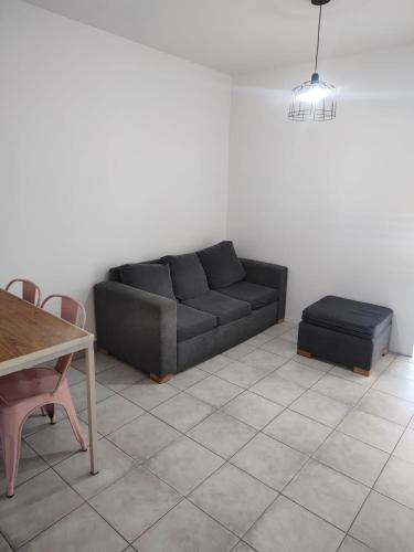 a living room with a black couch and a table at Departamento La Boca in Buenos Aires