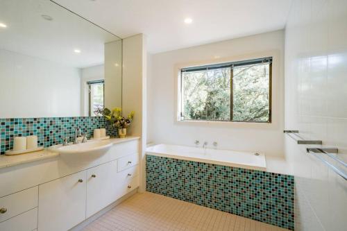 a bathroom with a sink and a tub and a window at Sea La Vie at Bayview - 'paradise by the sea' in Bay View
