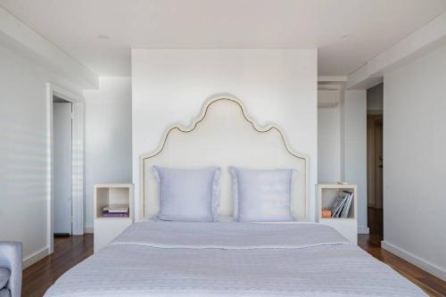 a white bedroom with a white bed with blue pillows at Sea La Vie at Bayview - 'paradise by the sea' in Bay View