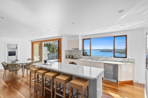 a kitchen with a large island with bar stools at Sea La Vie at Bayview - 'paradise by the sea' in Bay View