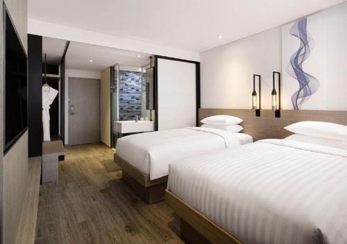 a hotel room with two beds and a television at Fairfield by Marriott Busan in Busan