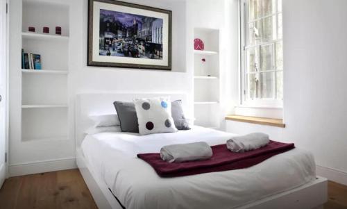 um quarto branco com uma cama com duas toalhas em Clamshell Land - Royal Mile em Edimburgo
