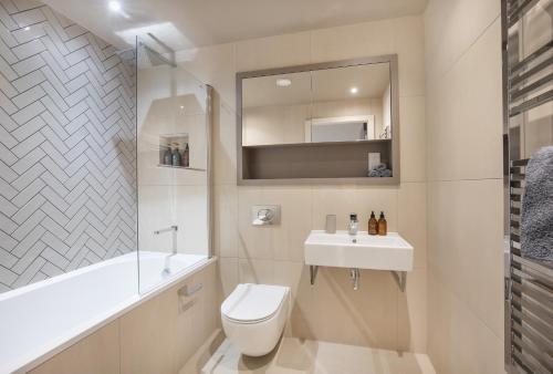a bathroom with a toilet and a sink and a mirror at York Central No 1, within the city walls, free parking in York