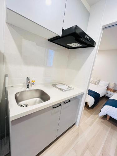 a white kitchen with a sink in a room at Year-end promotion 2 Gread location 1min to Station Closs Ueno Max 6 people Wi-fi unlimited in Tokyo