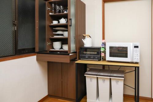 a kitchen with a counter with a microwave oven and a microwave at 1日1組限定の貸切の民泊です全館禁煙です屋外喫煙所無し間取りは2LDkです毎年12月8日から2月28日の駐車場は使用不可能です in Fukui