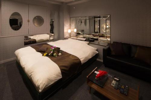 a bedroom with a large bed and a couch at プリンセスプリンセス秋田大町 in Akita