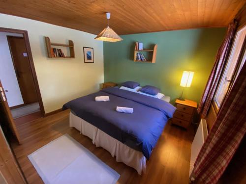 a bedroom with a blue bed in a room at B&B Chalet Les Frenes in Chamonix-Mont-Blanc