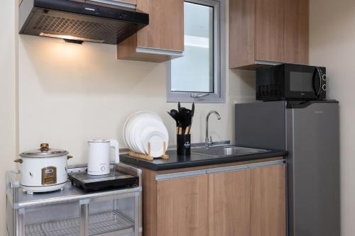 a small kitchen with a sink and a microwave at Furnished 1-Bedroom in Avida Towers Riala, Cebu IT Park with Fast WiFi, Netflix, Pool and More in Mabolo