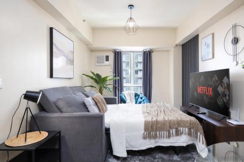a living room with a couch and a tv at Furnished 1-Bedroom in Avida Towers Riala, Cebu IT Park with Fast WiFi, Netflix, Pool and More in Mabolo