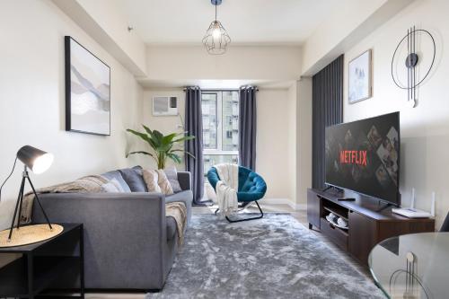 a living room with a couch and a tv at Furnished 1-Bedroom in Avida Towers Riala, Cebu IT Park with Fast WiFi, Netflix, Pool and More in Mabolo