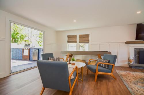 a living room with a table and chairs and a fireplace at Close2beach, Speakeasybar,hottub, Petsok, Firepit in Dennis