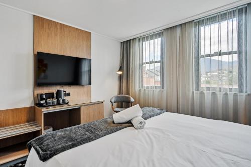 a hotel room with a bed and a tv at Prince of Wales Hotel in Hobart