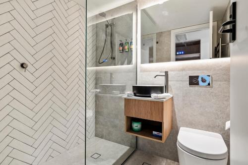 a bathroom with a shower and a toilet and a sink at Prince of Wales Hotel in Hobart