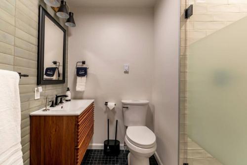 a bathroom with a toilet and a sink and a shower at Camp Smores- Modern A-Frame with Pool in Newfield