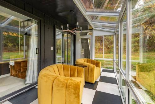 a screened in porch with two chairs and windows at Camp Smores- Modern A-Frame with Pool in Newfield