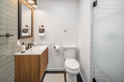 a bathroom with a toilet and a sink and a shower at Camp Smores- Modern A-Frame with Pool in Newfield