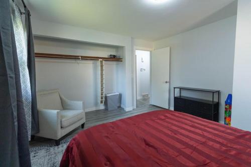 a bedroom with a bed and a chair and a television at Mi Casa Su Casa, 28 minutes from Lambeau Field! in Appleton