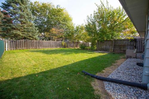 a backyard with a hose laying on the grass at Mi Casa Su Casa, 28 minutes from Lambeau Field! in Appleton