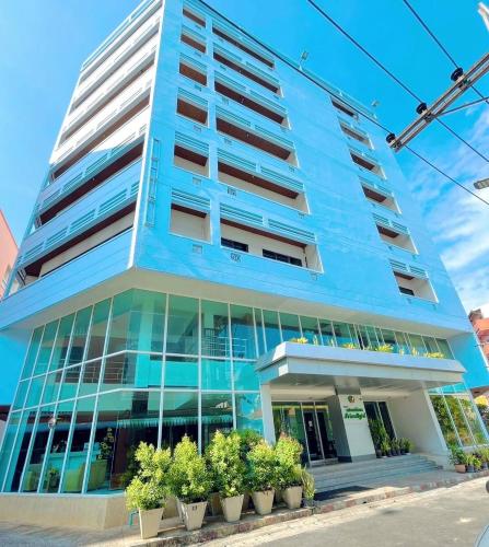 a blue building with potted plants in front of it at Friendlytel Hotel in Hat Yai
