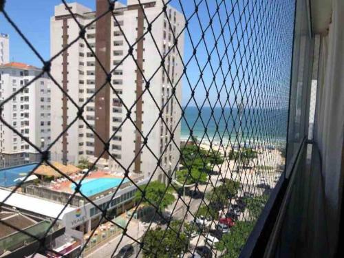 a view of the beach from a balcony of a resort at Apartamento maravilhoso na Pitangueiras Guarujá in Guarujá