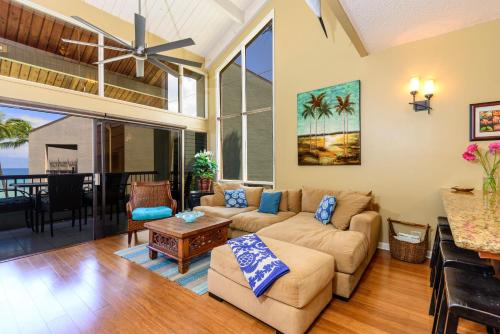 a living room with a couch and a table at Hale Mahina B401 · HM B401 OceanFront 2BD Tropical Getaway in Kahana