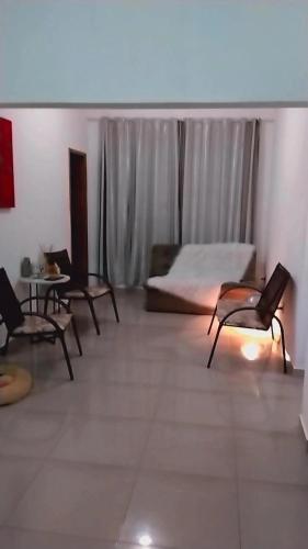a bedroom with a bed and chairs and a table at Casa aconchegante in Mendanha