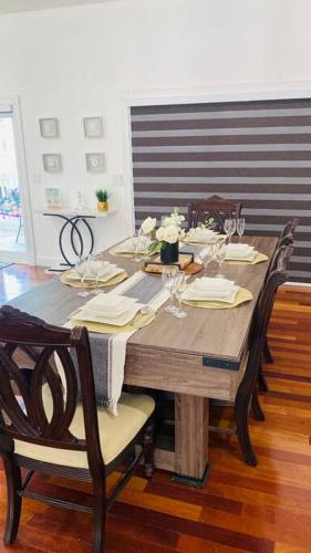 a wooden table with chairs and wine glasses on it at Lake Of Dreams Miami House in Miami