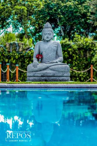 a statue sitting next to a pool of water at Lake Of Dreams Miami House in Miami
