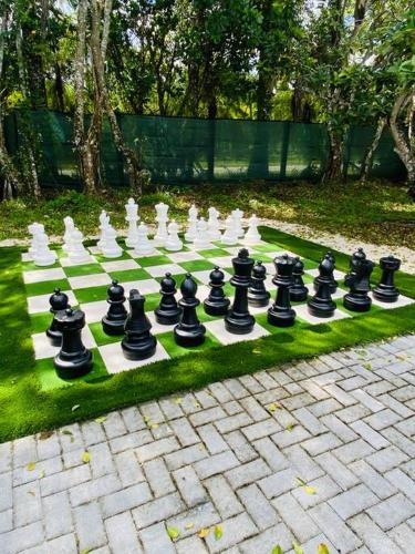 a chess board on the grass in a garden at Lake Of Dreams Miami House in Miami