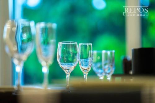 a row of wine glasses sitting on a table at Lake Of Dreams Miami House in Miami
