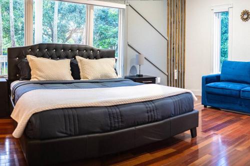 a bedroom with a large bed and a blue chair at Lake Of Dreams Miami House in Miami