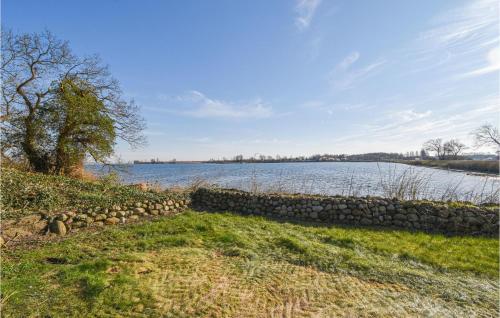 a stone wall next to a large body of water at Awesome Home In Otterup With Wifi in Otterup