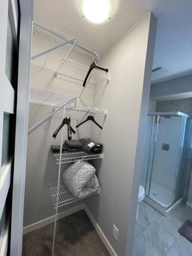 a bathroom with a walkin closet with towels and a shower at Comfortable and Beautiful Brand-New Suite BSMT-Two Bedroom, Two Washrooms in Calgary