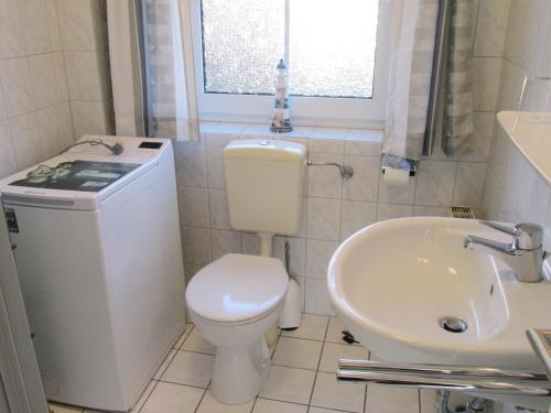 a small bathroom with a toilet and a sink at Ferienwohnung im Erdgeschoss in Neßmersiel in Neßmersiel