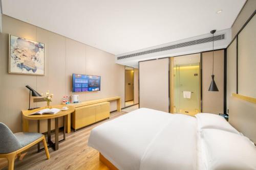 a hotel room with a bed and a desk at Echarm Hotel Kunming Changshui International Airport in Kunming