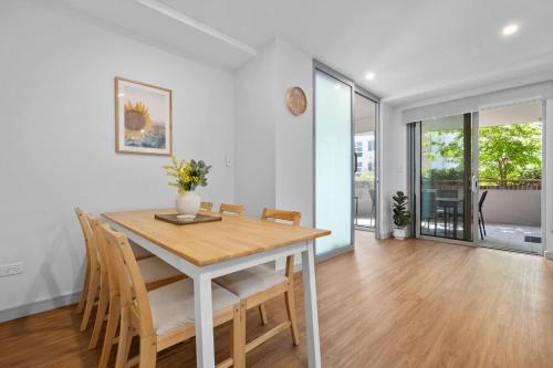 a dining room with a wooden table and chairs at Centrally Located Pymble Apartment in Pymble