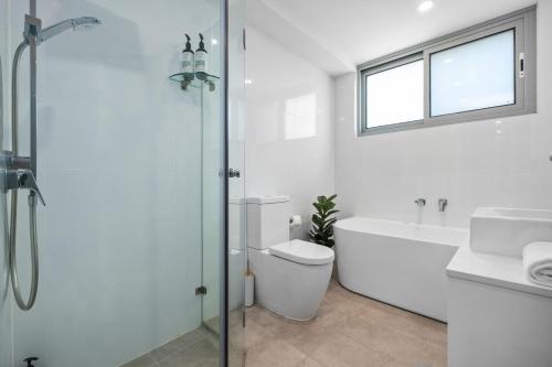 a bathroom with a toilet and a sink and a shower at Centrally Located Pymble Apartment in Pymble