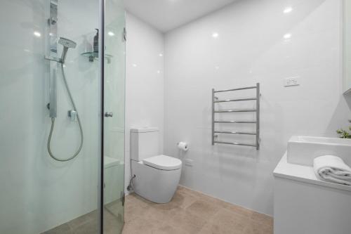 a bathroom with a shower and a toilet and a sink at Centrally Located Pymble Apartment in Pymble