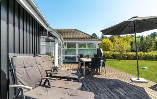 a patio with a table and chairs and an umbrella at Stunning Home In Knebel With Sauna in Knebel