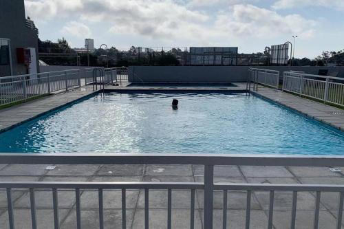 a person swimming in a large swimming pool at Departamento nuevo moderno y elegante in Viña del Mar