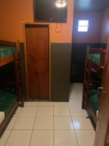 Habitación con puerta y TV en la pared en Pousada Portobello, en Recife