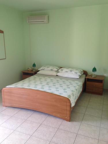 ein Schlafzimmer mit einem Bett mit zwei Nachttischen und zwei Tischen in der Unterkunft Apartments Villa Kristina in Pula