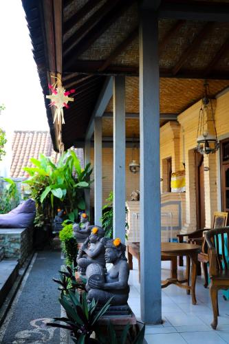 a group of people sitting on the porch of a house at The Wayan House Ubud in Ubud